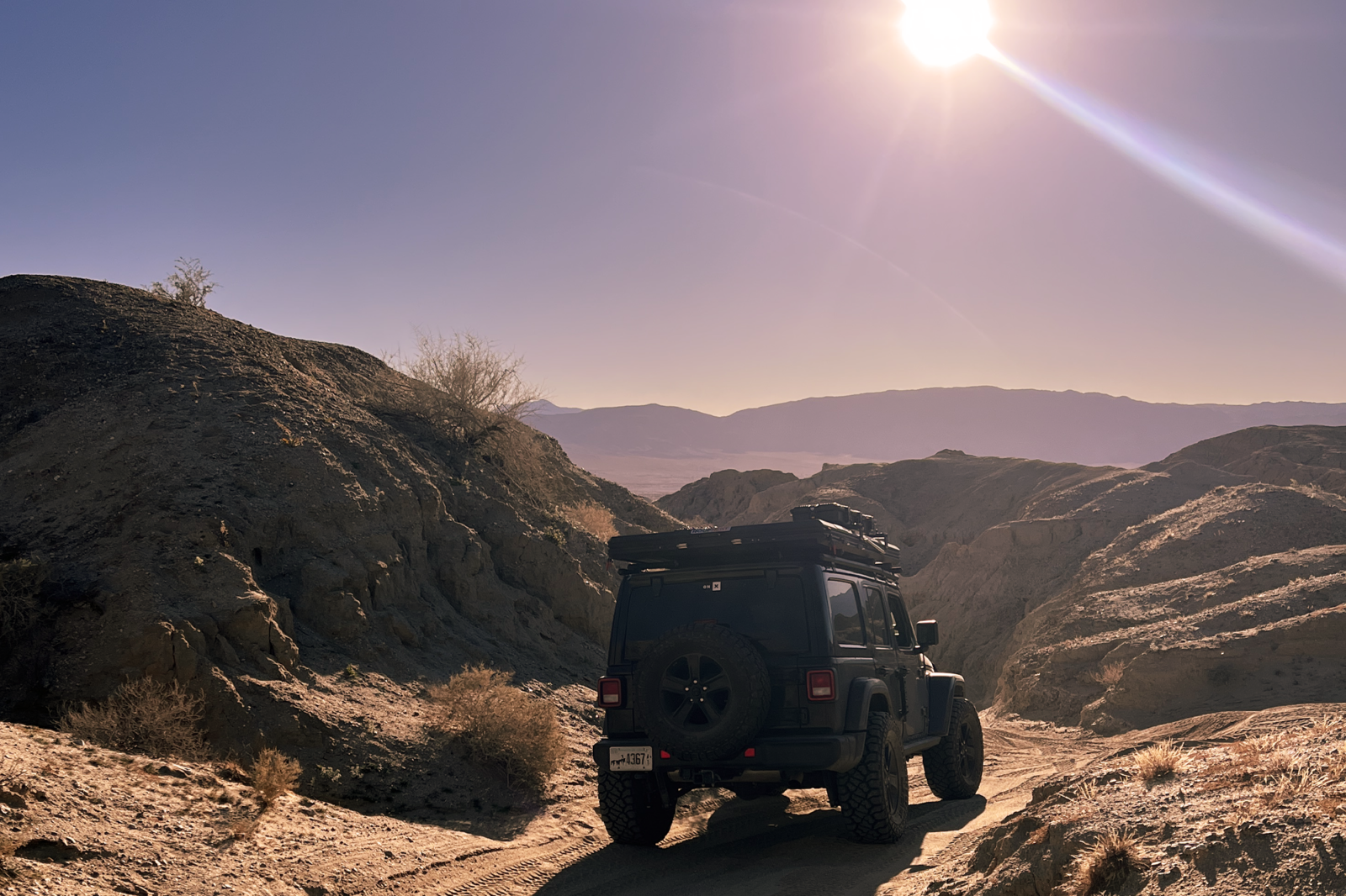 Off-roading jeep looking out over a mountain cliff